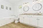 Primary bathroom ensuite with 2 sinks, soaking tub, shower, and laundry 